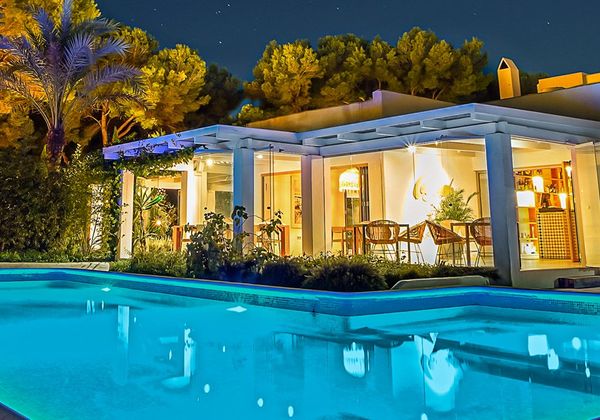 Villa con piscina iluminada de noche